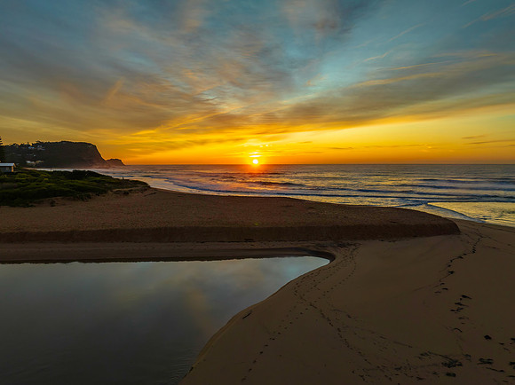 Sunrise and high cloud cover by the sea and lagoon