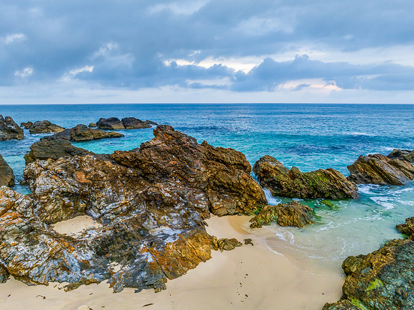 Rain clouds, rocks and sunrise at the seaside