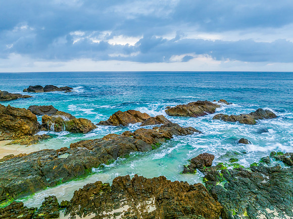Rain clouds, rocks and sunrise at the seaside