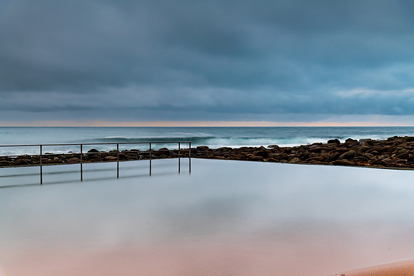 Rainy day sunrise at the beach and ocean pool
