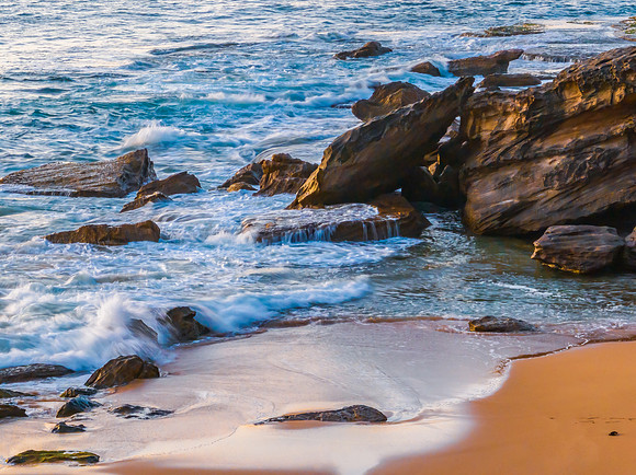 Sunrise over the blue sea and rocks at the beach