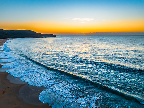 Pretty blue sunrise at the beach with calm seas