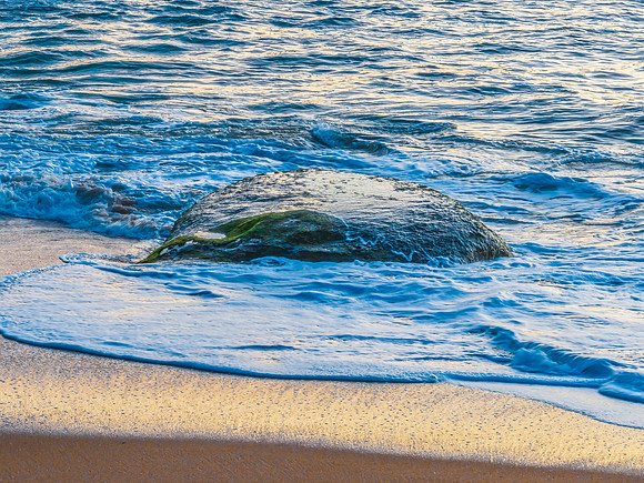 Aerial sunrise views over the ocean, beach and rock