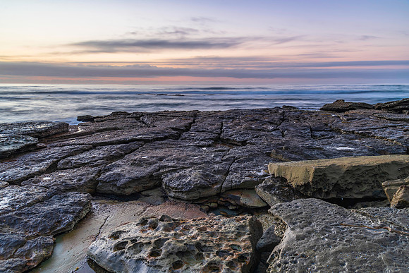 Sunrise seascape with rocky foreground