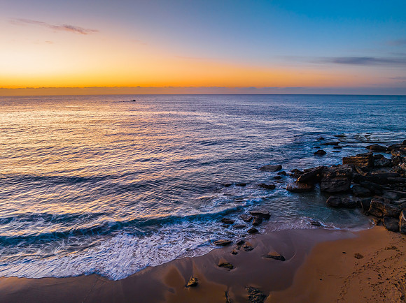 Pretty blue sunrise at the beach with calm seas