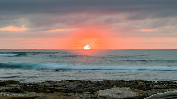 Sunrise seascape with rocky foreground