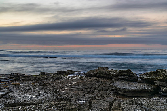 Sunrise seascape with rocky foreground