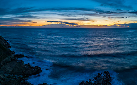 Sunrise over the sea and rock platform with high cloud