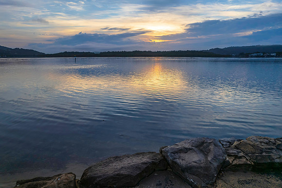 Soft and peaceful sunrise aerial waterscape with clouds and refl