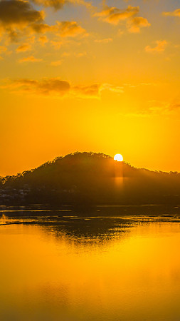 Aerial sunrise waterscape with boats, reflections and low cloud