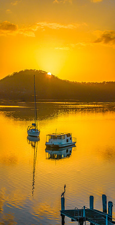 Aerial sunrise waterscape with boats, reflections and low cloud