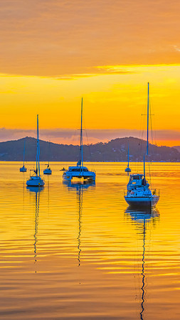Aerial sunrise over the water with boats and clouds