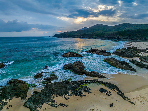 Rain clouds, rocks and sunrise at the seaside