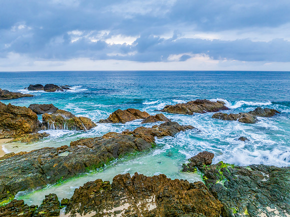 Rain clouds, rocks and sunrise at the seaside