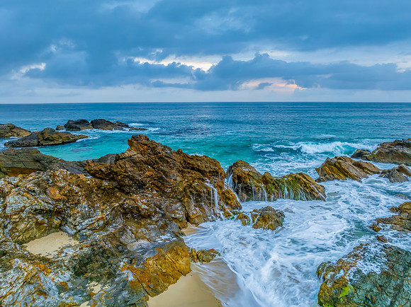 Rain clouds, rocks and sunrise at the seaside