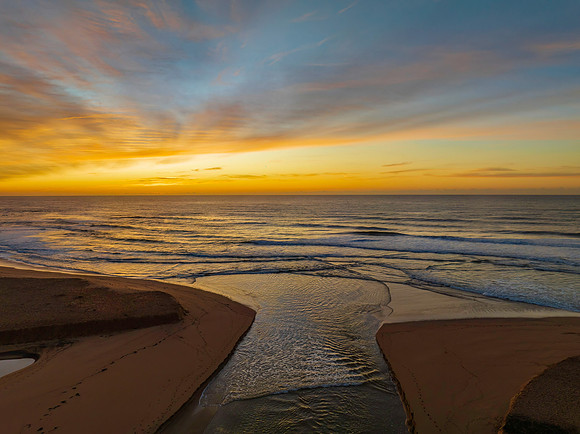 Sunrise and high cloud cover by the sea and lagoon