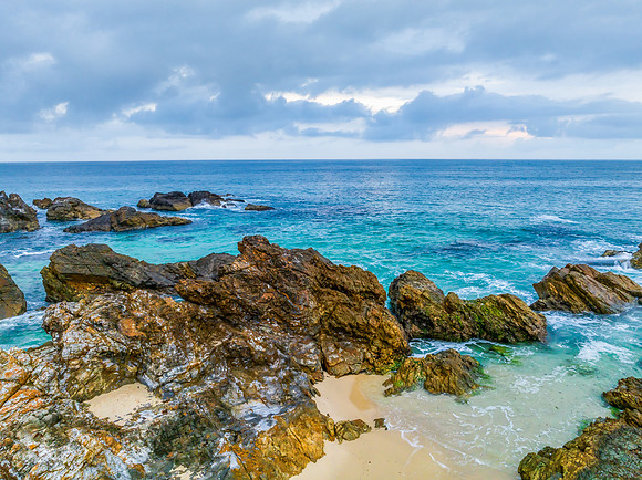 Rain clouds, rocks and sunrise at the seaside