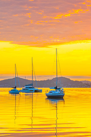 Aerial sunrise over the water with boats and clouds