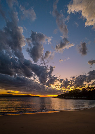 Sunrise over the ocean with clouds and a calm sea
