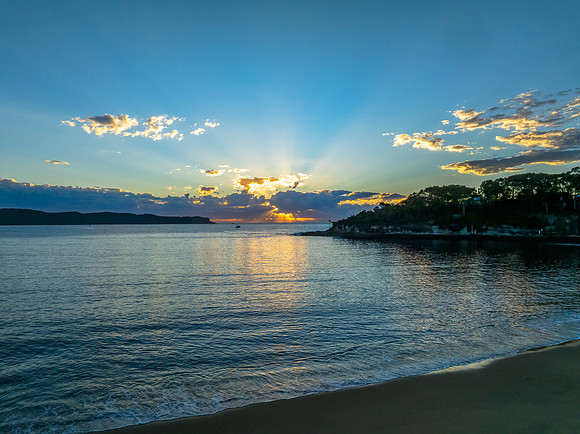 Sunrise over the ocean with clouds and a calm sea