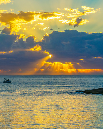 Sunrise over the ocean with clouds and a calm sea