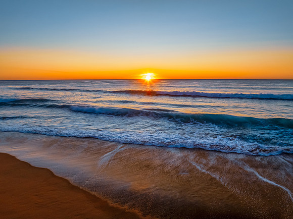 Sunrise at the seaside with clear skies and orange horizon