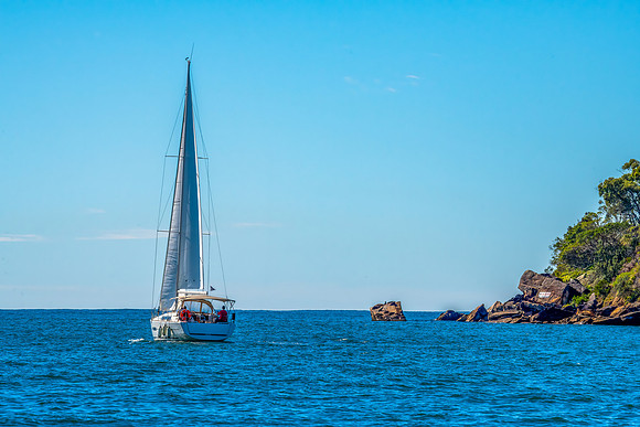 The blue sea and a yacht sailing on Broken Bay