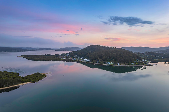 Soft and peaceful sunrise aerial waterscape with clouds and refl