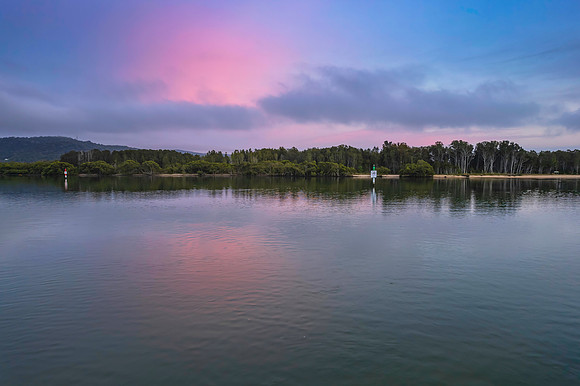 Soft and peaceful sunrise aerial waterscape with clouds and refl
