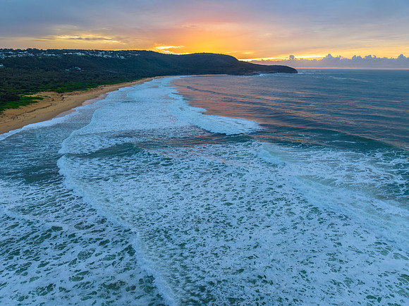 Cloud covered sunrise at the seaside in soft pastel shades