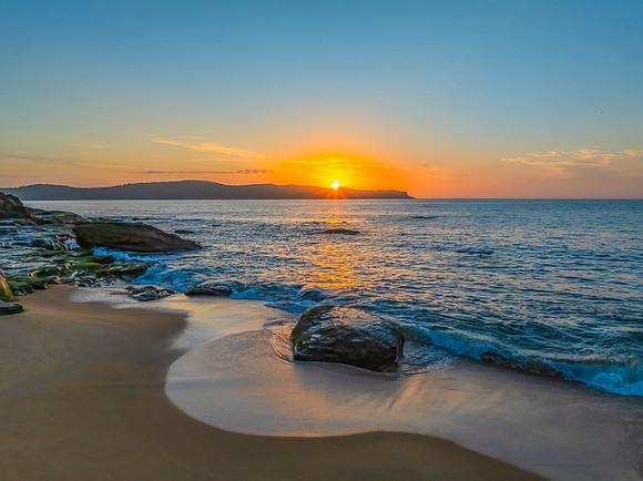 Aerial sunrise at the seaside with light scattered high cloud an
