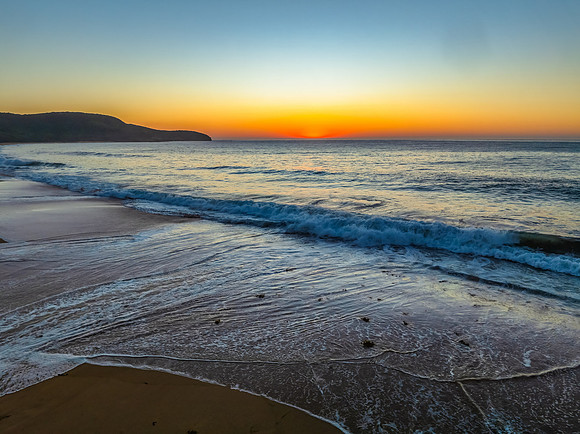 Sunrise seascape with clear skies and orange horizon