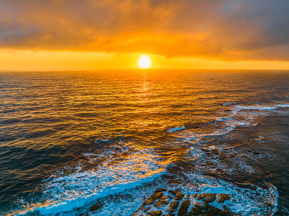 Cloudy sunrise over the ocean with rock platform