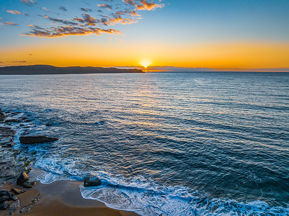 Aerial sunrise views over the ocean and beach