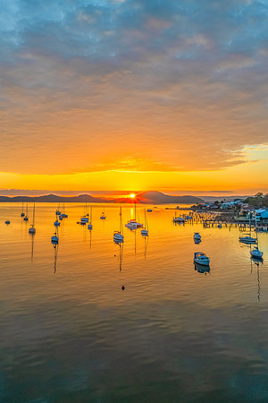 Aerial sunrise over the water with boats and clouds