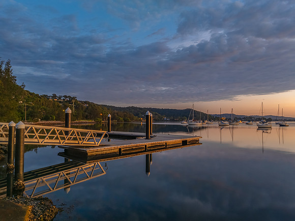 Aerial sunrise over the water with boats and clouds