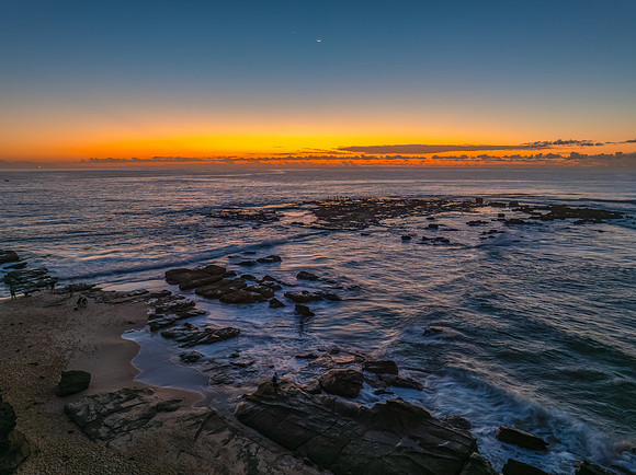 Dawn over the sea and rocks with clear skies