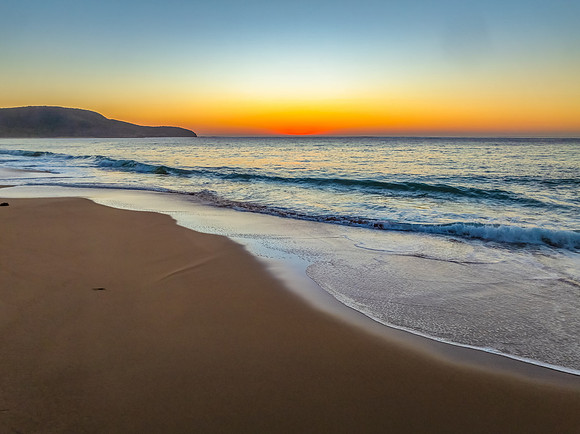 Sunrise seascape with clear skies and orange horizon