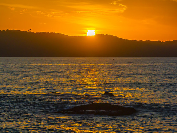 Aerial sunrise at the seaside with light scattered high cloud an