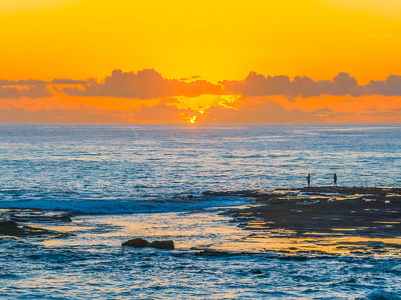 Sunrise over the sea and rocks with clear skies