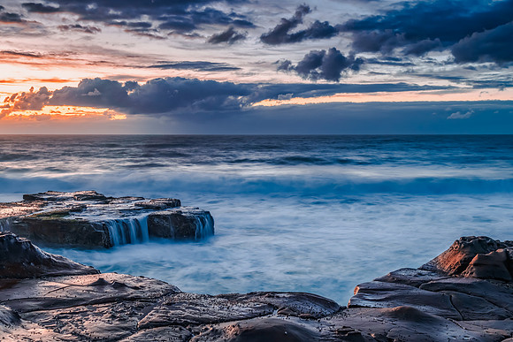 Sunrise, sea, waves, clouds and tessellated rock platform