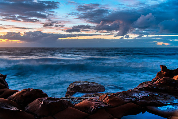 Sunrise, sea, waves, clouds and tessellated rock platform