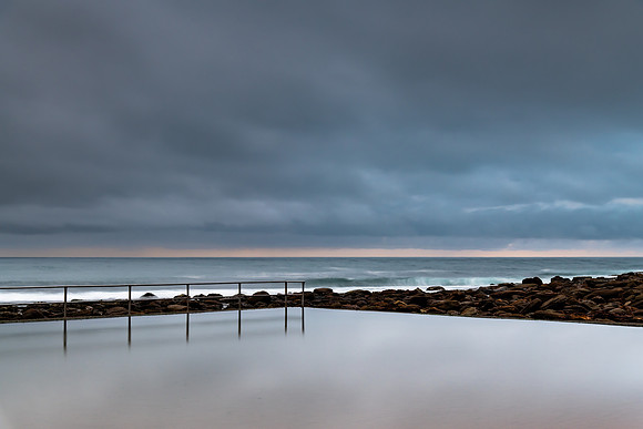Rainy day sunrise at the beach and ocean pool