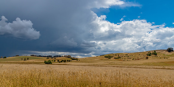 Countryside and storm clouds with blue sky