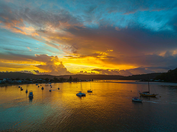 Aerial sunrise waterscape with boats, colour and clouds