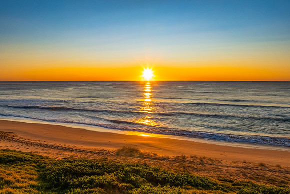 Sunrise at the seaside with clear skies and orange horizon