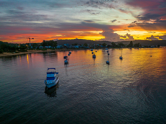 Aerial sunrise waterscape with boats, colour and clouds