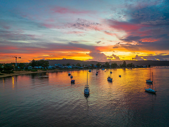 Aerial sunrise waterscape with boats, colour and clouds