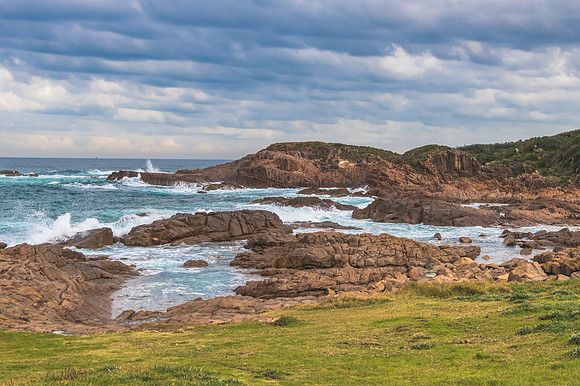 Rocky Seascape with Blue Aquamarine Sea and Earthy Brown Rocks