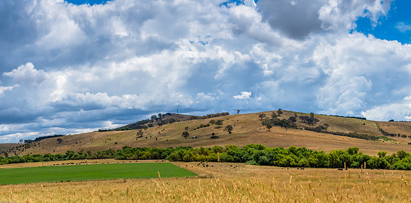 Countryside and storm clouds with blue sky